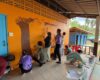 Nine Westminster students paint an image of a tree and a snake on the wall at a school in Thailand.