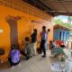 Nine Westminster students paint an image of a tree and a snake on the wall at a school in Thailand.